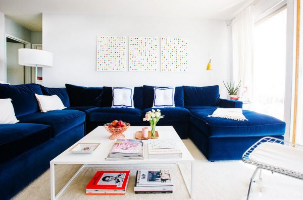 Большой синий диван в интерьере светлой гостиной