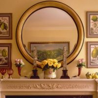 Круглое зеркало на портале камина