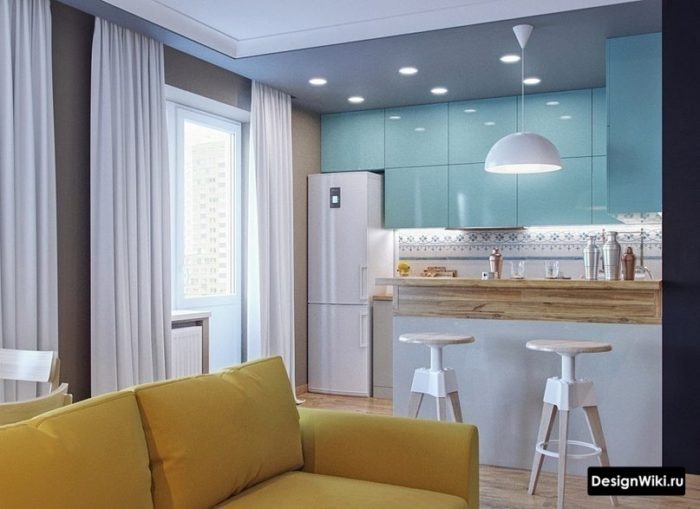 Голубые шкафы и желтый диван в кухне-гостиной с барной стойкой