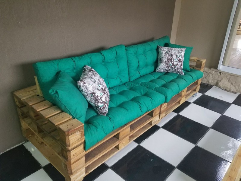 диван из деревянных поддонов зеленый матрас и пестрые подушки