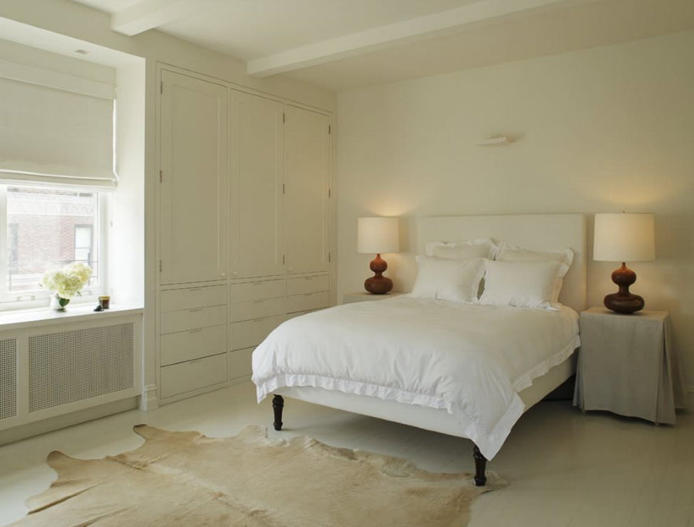 Белая кровать в спальне со светлыми стенами