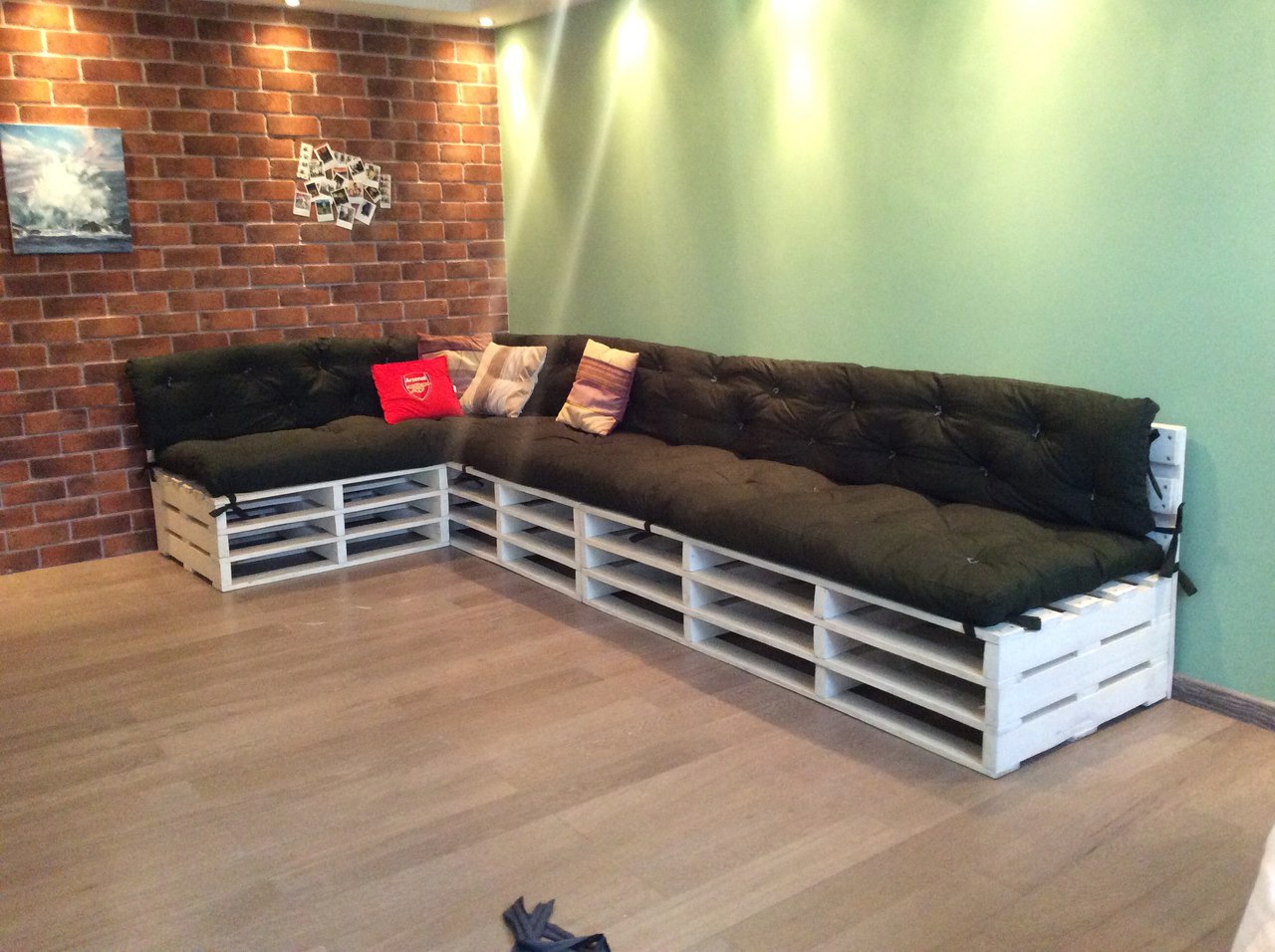 Угловой диван из поддонов черный матрас в комнате