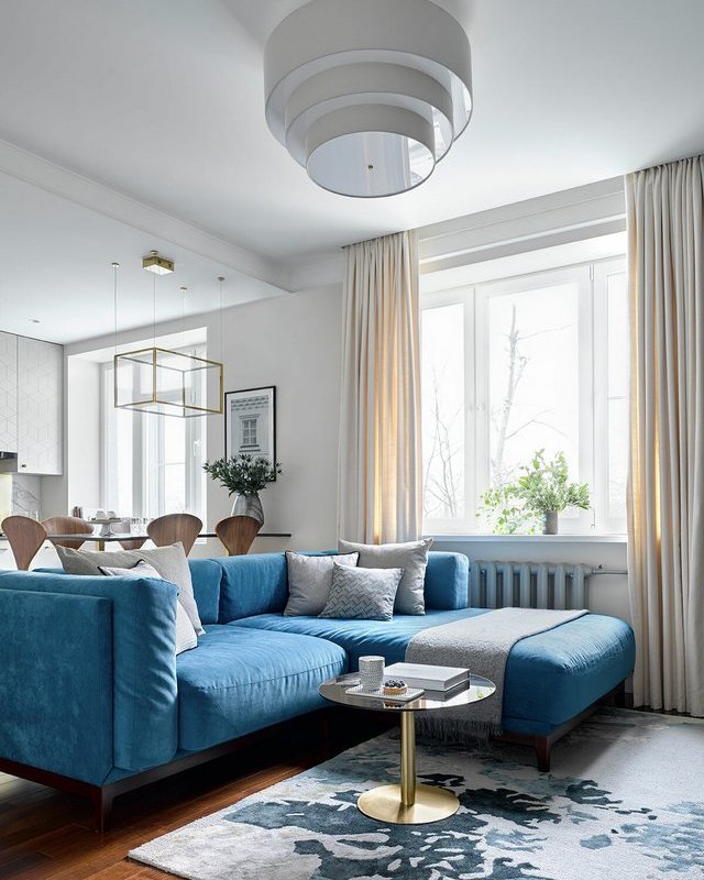 Синий угловой диван в интерьере гостиной городской квартиры