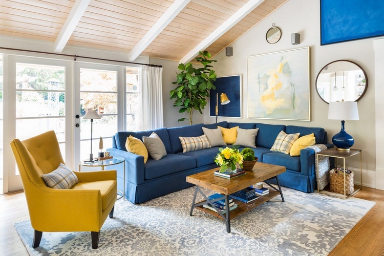 Синий угловой диван в интерьере гостиной 