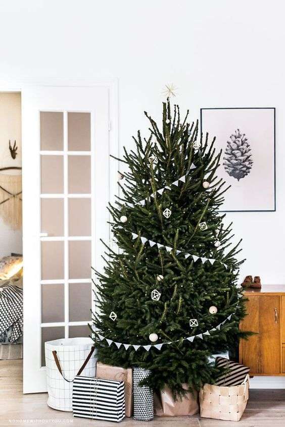 03-a-modern-scandi-tree-with-buntings-white-and-wooden-ornaments-and-a-star-on-top-plus-lights-9276859