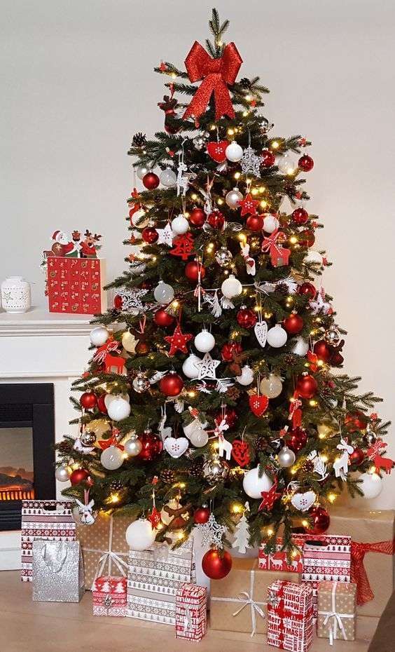 17-a-bold-traditional-christmas-tree-with-red-and-white-ornaments-of-various-shapes-lights-and-with-a-red-bow-on-top-7631173